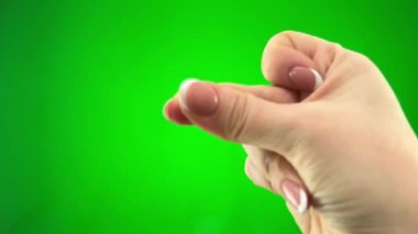 woman snaps fingers in frame with french manicure on a green chroma key background then shows two fingers up Victory close-up female hand emotions