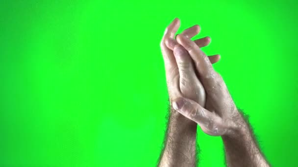 緑の背景に手のケアクロマキー男彼の手に白いクリームを広げる毛深い男性の手テキストやビデオのための画面スペースの右側にある写真 — ストック動画