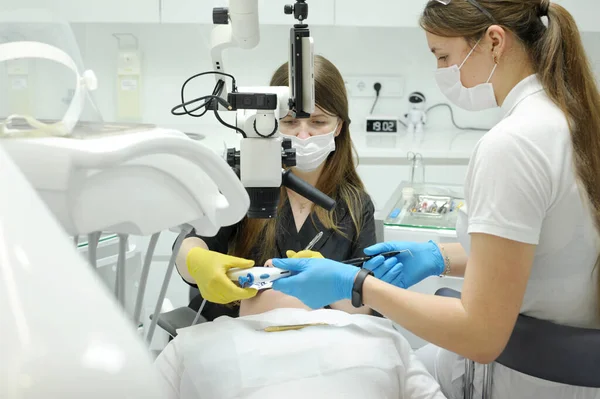 modern dental clinic root canal filling process using microscope other latest technology doctor nurse helping patient with toothache filling prosthetic stone removal microscope approach improvement