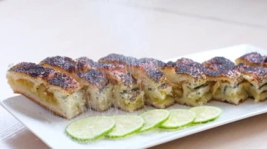 Sugar strudel pie with poppy seeds and apples will appear on white plate of the stripas. Table setting looks delicious. Restaurant serving. Baking