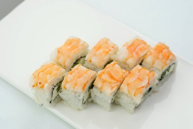 Sushiya lokantası için yer var. Asya, Japonya, lezzetli yemekler. Beyaz tabakta karides ve sekiz parça salatalık, Philadelphia peyniri.