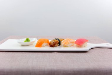 Suşi seti sashimi ve suşi ruloları beyaz slate ton balıklı karidesli kırmızı balıklı soya balıklı soya peynirli soya balığı ve çubuklu Asya yemekleri nefis Japon restoranlarında servis edilir.