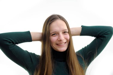 Beyaz arka planda mutlu görünen gülümseyen genç bir kadının portresi. Yüzünde kocaman bir gülümseme güzel ve tatlı görünüyor. Elleri uzun yeşil saçlarına dokunuyor.