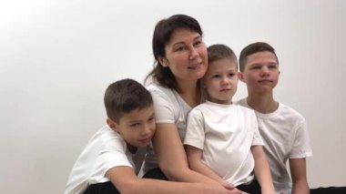 mother and three sons brothers children on white background school washing powder hygiene product cleanliness White t-shirts clothing store sitting looking like Ivan studio social services desire