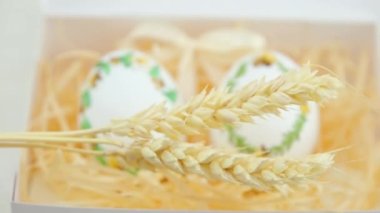 eggs embroidery with ribbons on eggshells three spikelets of wheat appear in front of them blur sharpness moves to fore Easter art needlework handmade technology agriculture goose Ostrich eggs