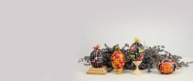 Easter holiday banner place for text advertising business card invitation announcement lavender flowers background painted with red black eggs with tuft wooden stands in right corner handmadelavender