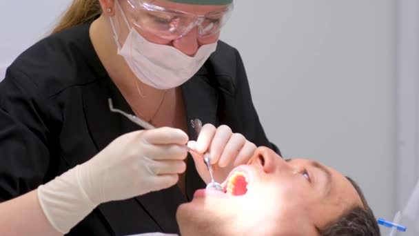 歯科事務所では歯医者と助手が手術の概念を取り除く手術を行っています — ストック動画