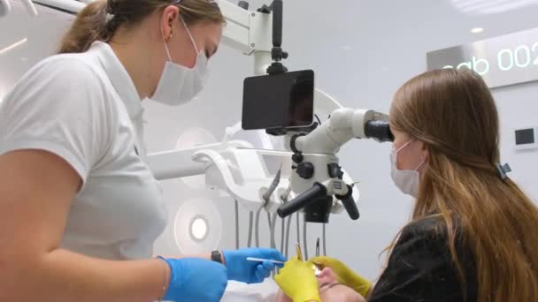 Paciente Femenina Abriendo Boca Bajo Microscopio Dental Dentista Profesional Sosteniendo — Vídeos de Stock
