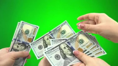 on green background chromakey male hands give one hundred dollar bills to female hands woman counts each banknote considering its authenticity at end they show thumbs up happy with deal resolution buy
