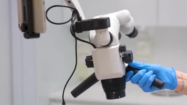 护士和医生在牙科诊所手中的显微镜特写安装了设备平板和显微镜 用最新的技术 用黄色和蓝色手套填充运河 — 图库视频影像
