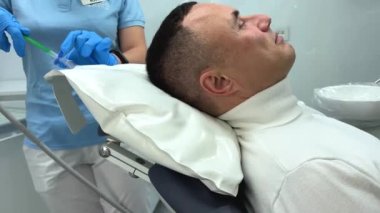 Diş hekimi için şişirilebilir yastık, baş doktor kaldırır. Yastık, dişçi muayenehanesinde baş ve boyun pozisyonu alır. Rahat diş tedavisi anestezisi.