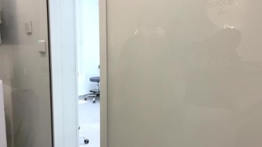 En son teknoloji dişçilik elektronik olarak kapıyı açıyor kamera içeri giriyor ve dişçi koltuğundaki hastanın fotoğrafını çekiyor beyaz renk temizliği kısırlığı etrafında soyuluyor.