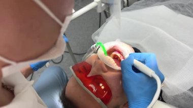 Diş fırçalama, tartar ve diş bakımı, diş bakımı ve hijyen, diş implantı için diş hazırlayan yetişkin beyaz dişçi diş implantı, diş hekimlerinin müdahalesi yüzünden kanıyor.