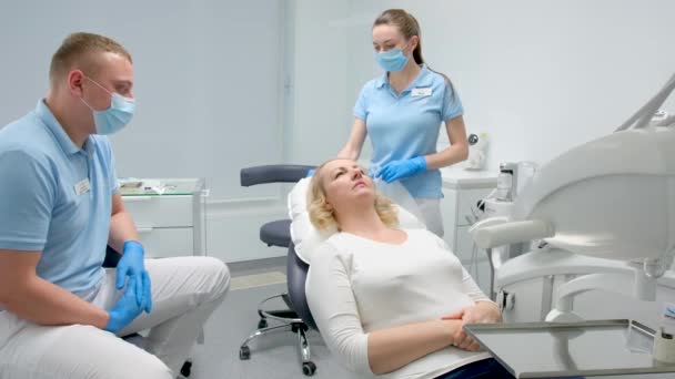 Waiting Dental Procedures Woman Lies Chair Man Doctor Nurse Stand — Video Stock