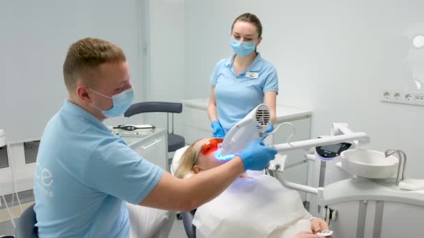 Clínica Dental Dentes Branqueamento Mulher Deitada Sob Aparelho Médico Enfermeiro — Vídeo de Stock