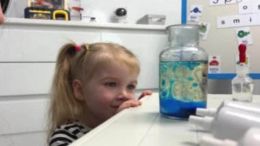 Scientific experiment at home. Laboratory tests for school homework. Parent mother with daughter kid making chemical test at home kitchen. Nanny babysitter teacher help in protective glasses
