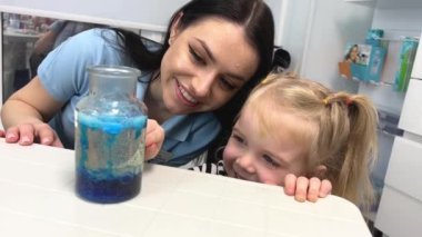 Little scientist. Curious daughter play with mom engaged at education activity make funny experiment. Interested small girl watch elder sister doing chemical test use chemistry set kids