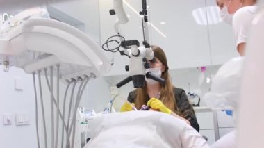 Modern dental clinic with a microscope for the treatment of patients.A male dentist looking through the eyepiece of a microscope.Medical equipment,dental clinic concept of healthcare and medicine