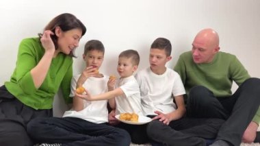 family eating eclairs A large and friendly family has lunch at home. High quality 4k footage
