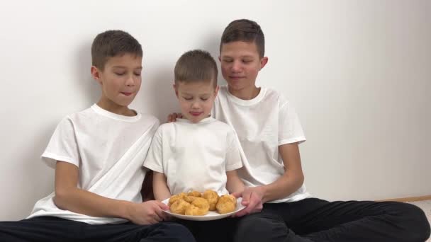 Три Симпатичных Мальчика Братья Едят Эклеры Дома Солнечная Гостиная Три — стоковое видео