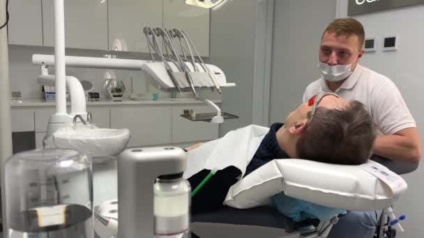 牙椅病人充气枕头抬起头来主治医生把枕头放在他的脖子和头在牙科诊所舒适舒适舒适的牙科治疗麻醉放松 — 图库视频影像