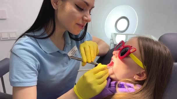 Θεραπεία Των Παιδιών Δόντια Του Γάλακτος Οδοντίατρος Γυναίκα Εξετάζει Παιδιά — Αρχείο Βίντεο