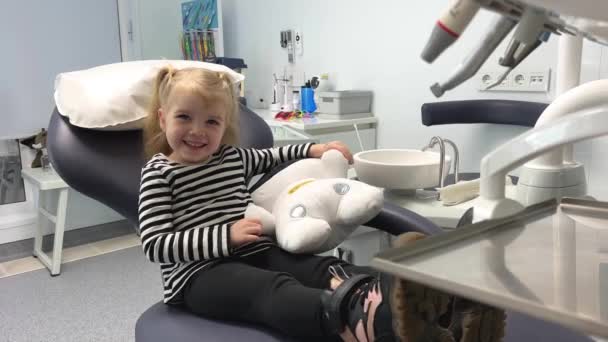 Uma Menina Uma Blusa Listrada Consultório Odontológico Com Brinquedo Macio — Vídeo de Stock