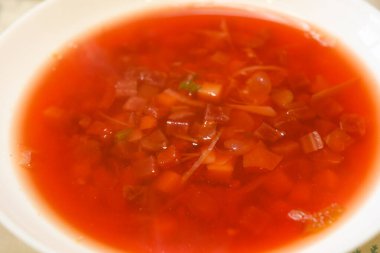 red Ukrainian vegetarian vegetable borscht cabbage beet carrots potatoes beans various ingredients boiled and poured into white plate overcooked canteen empty light borscht