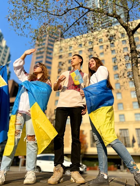 three teenagers went to a demonstration for peace in Ukraine waiting for the end of the war No war love for Ukraine emigrants are waiting for return home Russian terror children with flag of Ukraine