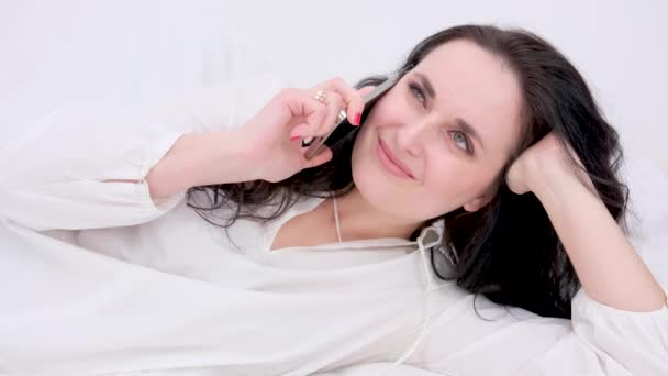 Mujer Hablando Por Teléfono Riendo Sinceramente Sonriendo Acostada Lado Mirando — Vídeos de Stock
