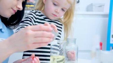 Elementary School Science Chemistry Classroom: Enthusiastic Teacher Shows Funny Chemical Reaction Experiment to Diverse Group of Children. Mixing Chemicals in Beaker so they Shoot Foam
