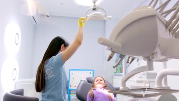 Lekarz Dentysta Kieruje Światło Twarzy Dziewcząt Przygotowaniu Gabinetu Stomatologicznego Badania — Wideo stockowe