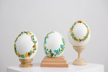 lavender background postcard baner calendar empty space holiday easter eggs embroidery ribbons on eggshell krashanka three eggs on special wooden stands on a white background
