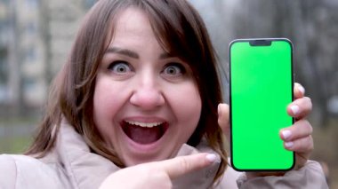 Beautiful happy Asian businesswoman showing phone in the streets outdoors. High quality 4k footage