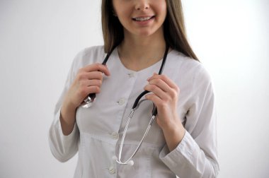 Attractive young nurse with a stethoscope. Looking into the upper-left corner. Isolated on a gray background. High quality photo