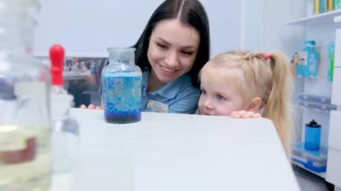Little scientist. Curious daughter play with mom engaged at education activity make funny experiment. Interested small girl watch elder sister doing chemical test use chemistry set kids