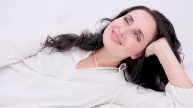 Güzel, 40 'lı yaşlarda olgun bir kadın beyaza izole edilmiş kameraya bakıyor. Olgun, yaşlı bir kadın portresi. Sağlıklı yüz bakımı güzellik, cilt estetiği, kozmetik konsepti