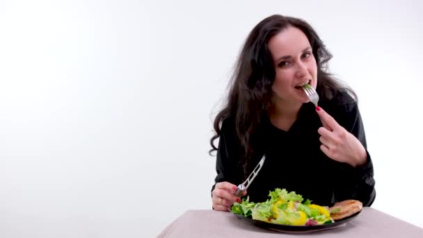 White Background Woman Black Clothes Eats Salad Meat Fork Looks — Vídeo de Stock