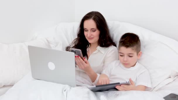 Work Home Online Mom Son Sit Bed White Blanket Hands — Stockvideo