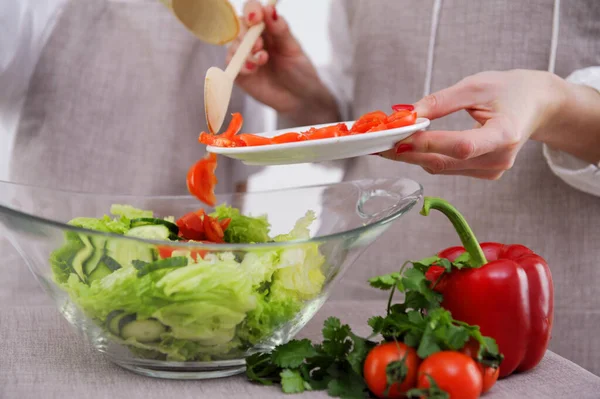 woman in the process of preparing healthy food Vegetable Salad mixing salad wooden spoon in kitchen at home Dieting Concept. High quality photo