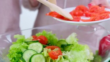 woman in the process of preparing healthy food Vegetable Salad mixing salad wooden spoon in kitchen at home Dieting Concept. High quality photo