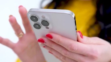 female hands with mobile phone woman leafing through pages white mobile phone orange clothes message internet social networks