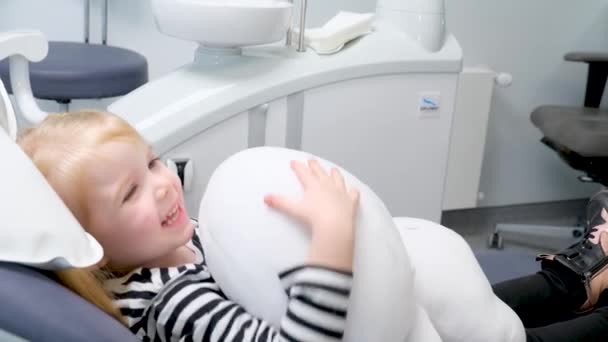 Little Girl Dental Chair Has Fun Playing Stuffed Toy Talking — Vídeo de Stock
