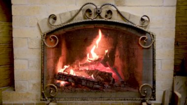Classic stone fireplace with a bright flame burning wood. High quality 4k footage