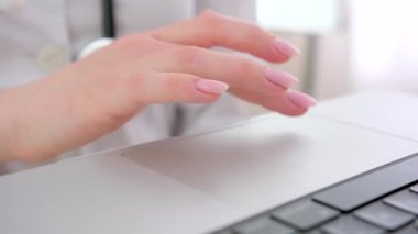 Close up woman doctor working on laptop, typing on keyboard, therapist physician nurse sitting at work table in hospital office, using medical apps, consulting online, writing report. High quality 