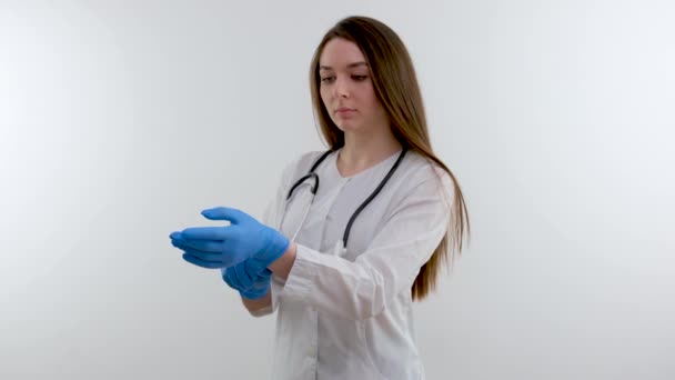 医者が青い医療用手袋を手にしている白人だ グレーの背景にスタジオ写真 水平だ 高品質の写真 — ストック動画