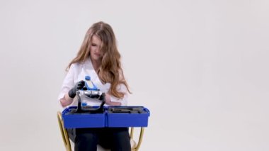 on a white background in studio assembling a dental articulator The doctor sits in a chair twists the articulator space for text advertising dentistry dentures dental prosthetics