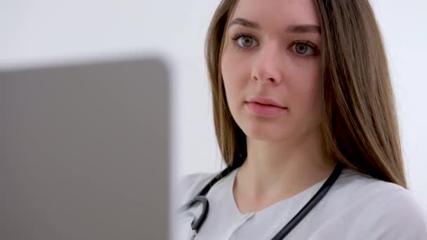 Asistente Médica Femenina Lleva Abrigo Blanco Auriculares Vídeo Llamando Paciente — Vídeo de stock