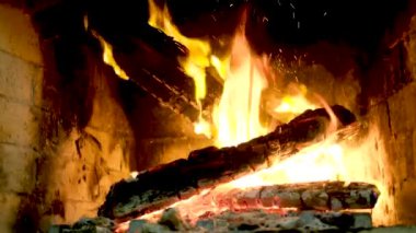 Big Bonfire Burns at Night in Slow Motion. Fire Flames on a Black Background. Fire sparks and flying embers in dark. Large raging campfire of wood. Real campfire from branches burns on nature