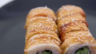 Camera ride on roll with eel. Close-up shot. Japanese cuisine Unagi Nigiri eel sushi on a tray rotating sushi with rice and fresh fish. High quality 4k footage